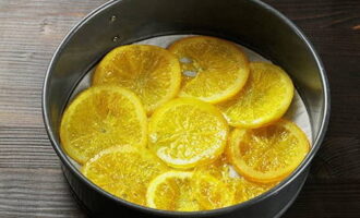 Апельсины достаем из сиропа и даем им остыть. Выкладываем продукт ровным слоем в форму для выпекания.