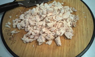 Отваренную до готовности курицу немного остудите, отделите мясо от косточек и мелко нарежьте.