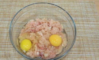 Измельченное мясо переложите в миску, разбейте к нему оба куриных яйца. 