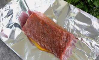 Разложите на ровной поверхности два листа фольги. Положите на фольгу подготовленное мясо.