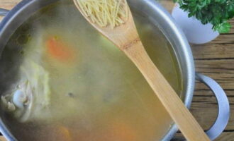 Далее выложите в бульон морковку, варите суп еще 10-15 минут. Когда морковка станет мягкой, выложите в бульон вермишель, посолите и приправьте суп по вкусу. Также закиньте один лавровый листик, а вот луковицу из бульона можно убрать.