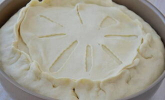 Лепешку с надрезами положите на пирог и соедините ее с основным круглым швом.