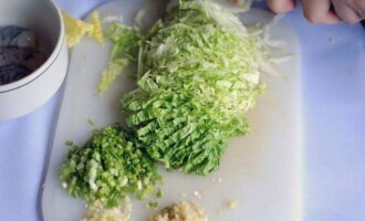 Зеленые листья китайской капусты нарезаем тонкой соломкой, подготавливаем имбирь и чеснок. Также шинкуем шнитт-лук.