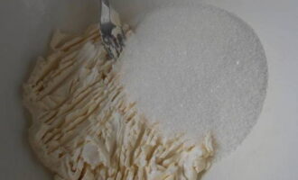 Размягченный маргарин соединяем в глубокой миске с сахаром. Хорошенько разминаем его вилкой.