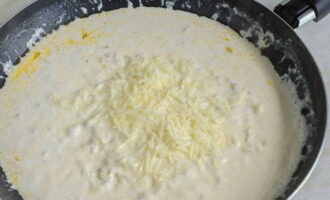 В сливочный соус отправляем часть измельченного сыра.