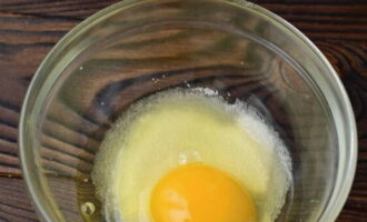 В отдельной посуде соединяем куриное яйцо, сахар и соль. Перемешиваем продукты до однородности.