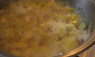 В кипящую воду насыпаем немного соли и перекладываем подготовленную картошку. После вторичного закипания уменьшаем нагрев и варим до готовности, накрыв крышкой.