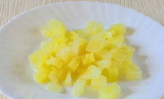 Консервированный ананас отделяем от жидкости и также некрупно нарезаем.