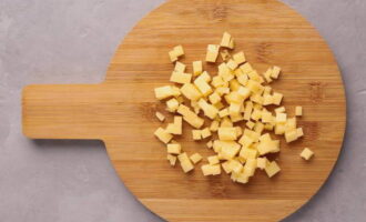Небольшими кубиками нарезаем твердый сыр.