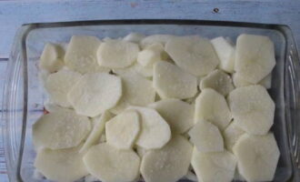 Следующим слоем распределяем тонкие слайсы картошки, не забываем подсолить.