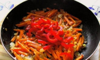 Как только морковь станет мягче, дополняем содержимое соломкой болгарского перца.