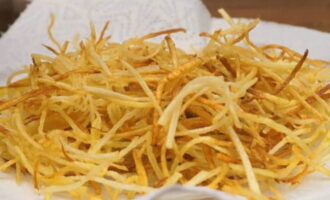 Обжариваем картофельную соломку на растительном масле до румянца. После выкладываем ее на бумажное полотенце и солим по вкусу.