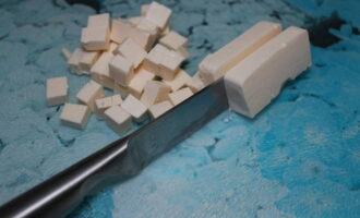 Плавленые сырки режем кубиками. Отправляем их в суп за 5 минут до готовности. Перемешиваем, чтобы сыр расплавился.