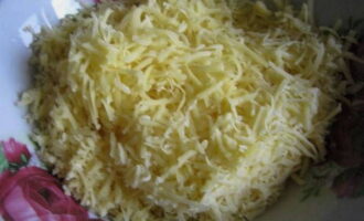 Очищенный картофель натрите на крупной терке. Также на терке измельчите твердый сыр.