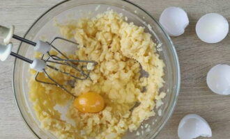 Далее по одному вмешайте в тесто все куриные яйца. Это можно делать лопаткой или миксером.