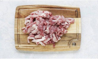 Промываем и обсушиваем мякоть свинины. После продукт режем небольшими брусочками. Если на мясе присутствует много жира, то удаляем его.