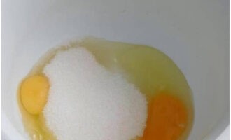 В глубокую миску разбиваем куриные яйца, дополняем их сахаром. Начинаем вымешивать венчиком.