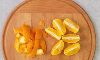 С апельсина тонко срезаем цедру. Очищаем фрукт от кожуры. Делим на дольки, внимательно извлекая косточки.