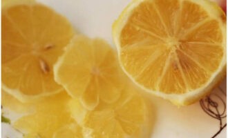 Очищаем лимон от кожуры и косточек. Оставшийся плод режем тонкими колечками.