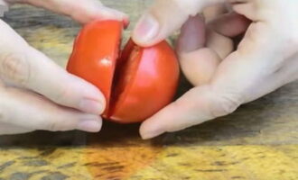 Промываем помидоры и надрезаем их на две части, не разрезая до конца.