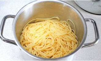Отлейте 50 мл макаронного отвара. Спагетти откиньте на дуршлаг и сразу переложите обратно в кастрюлю, ведь важно оставить их горячими.
