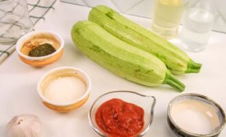 Как заготовить обалденные кабачки в томатном соусе на зиму? Первым делом подготовьте все ингредиенты, согласно пропорции рецепта. Кабачки промыть. Очистить чеснок.