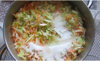 Выкладываем нарезанные овощи в кастрюлю. Дополняем их солью, сахаром и половиной растительного масла. Перемешиваем и оставляем на 10 минут для выделения сока.