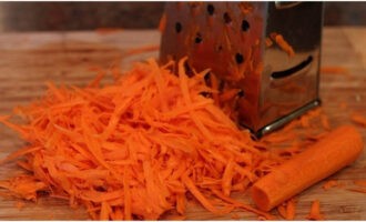 Очищаем от кожицы морковку, воспользовавшись экономкой, и трем на терке. Для большого количества овощей удобнее использовать кухонный комбайн.