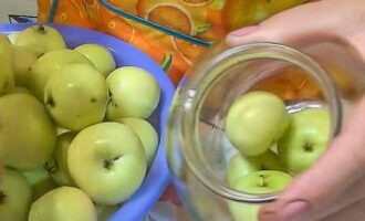 Яблоки выкладываем в чистые банки. Сперва кладем большие плоды, после – поменьше.