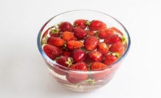 Залить ягоду холодной водой и оставить на несколько минут. Хотя клубника на вид и чистая, но промыть ее надо.