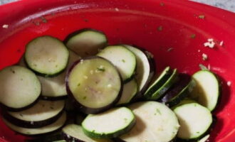 Складываем овощи в миску и приправляем двумя столовыми ложками подсолнечного масла, зубчиком чеснока, пропущенным через пресс, рубленой зеленью и солью с перцем – перемешиваем и оставляем для пропитки на 60 минут.