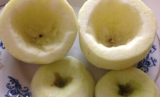 Счищаем кожицу с яблок и чайной ложкой удаляем семенную коробочку, срезав верх. Смазываем соком лимона, дабы фрукты не изменили свой цвет.