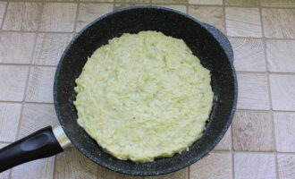 Раскалив сковородку с растительным маслом, распределяем основу пиццы, разравнивая лопаткой.