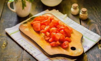 Промойте и обсушите помидоры. Нарежьте их такими же кубиками, как и баклажаны.