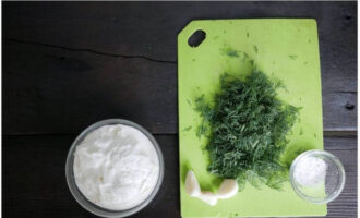 Не теряя времени, смешиваем сметану с измельченным чесноком, солью и рубленой зеленью.