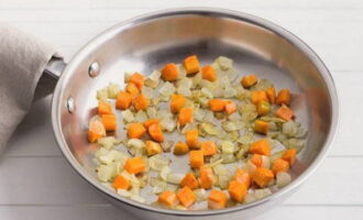 К нему добавьте кубики моркови и обжарьте до легкого золотистого цвета.