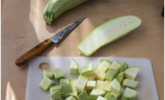 Как вкусно приготовить кабачки в мультиварке? Овощи промываем и очищаем, кабачок нарезаем кубиками среднего размера.