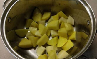 Картофель чистим, промываем, нарезаем крупными кусочками и сразу перекладываем в кастрюлю для тушения.