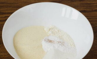 В тарелке с высокими бортиками смешиваем разрыхлитель, манку, муку, два вида сахара и молотую корицу.