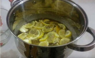 В кипящий сироп переложить нарезку лимона и на небольшом огне поварить 5 минут.