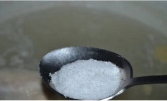 Добавляем соль в кипящий бульон с рисом.