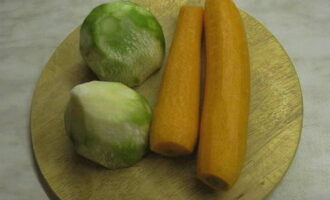 Очистите и промойте морковь с зеленой редькой. Ее можно заменить таким же количеством дайкона. С помощью кухонного комбайна или корейской терки эти овощи измельчите тонкой стружкой.