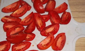 Остальные помидоры режем на более крупные дольки. Выкладываем их в общую массу.