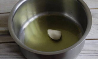 В кастрюлю с толстым дном влейте оливковое масло. Затем на прогретое масло выложите очищенный зубчик чеснока и обжарьте его в течение 1-2 минут. Чеснок нужен только для того, чтобы масло благодаря ему стало ароматным. Потом его можно выбросить.