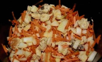 Овощи очистить и промыть. Морковь нарезать тонкой соломкой, а лук тонкими четверть кольцами. Через 15 минут к обжаренному куриному филе переложить нарезку овощей и продолжить жарку еще столько же.