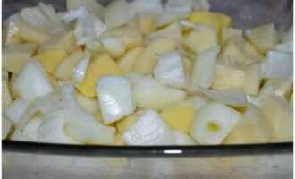 Перед началом готовки почистить и промыть картофель с луком. Нарезать овощи крупно. Стеклянный противень немного смазать растительным маслом, выложить нарезку овощей, посыпать их солью, перемешать и распределить ровным слоем.