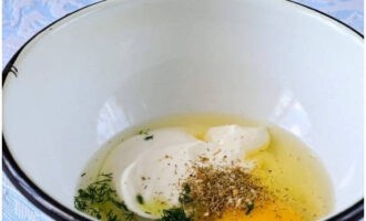 В глубокой миске соединяем сметану, куриное яйцо, соду, соль, специи и измельченный укроп.