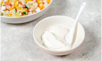 В отдельной пиале смешать по две ложки сметаны с майонезом и добавить к ним немного соли. Этим соусом заправить салат и аккуратно перемешать.