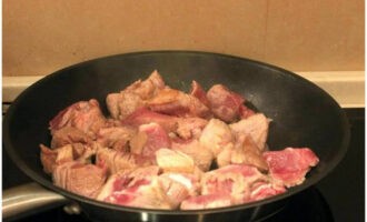 Обжарить мясо на той же сковороде, на большом огне и до румяной корочки со всех сторон. Затем налить к нему немного воды и потомить под крышкой 15-20 минут до мягкости. Вода должна полностью выкипеть.