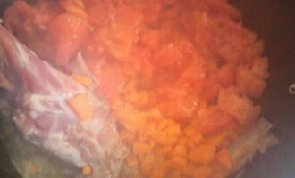 Теперь в огнеупорную посуду отправляем томаты и морковку, перемешиваем и тушим около 10-15 минут.